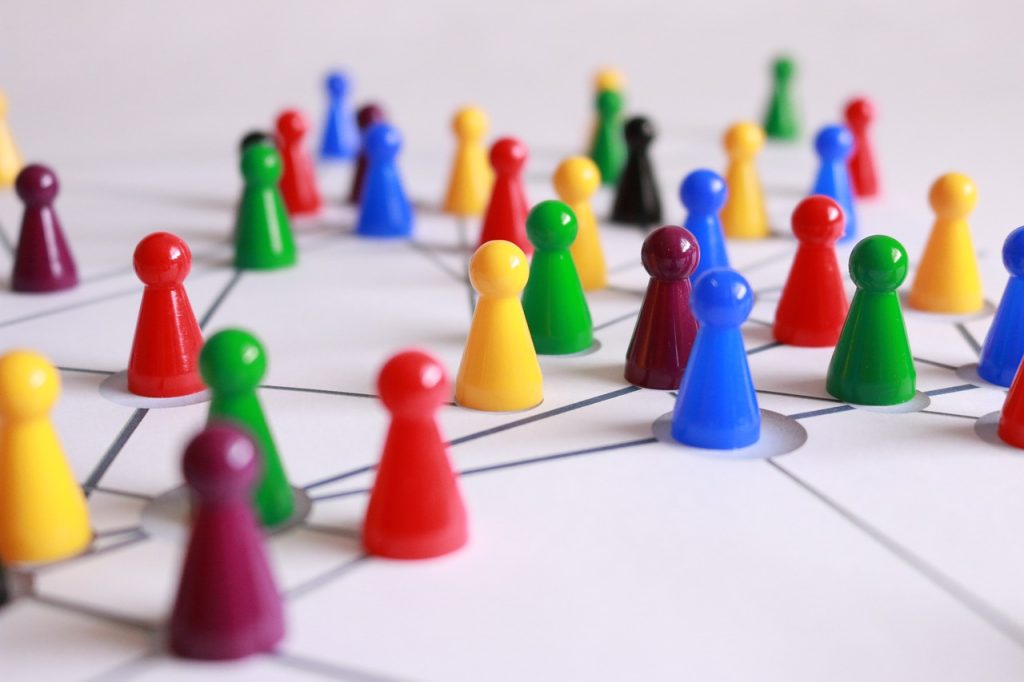 A variety of colorful game pawns of different colors placed on a grid, symbolizing multicultural and cultural diversity.jpg